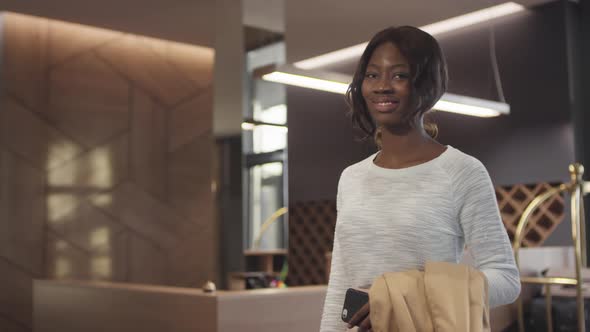 African-American Woman Posing in Lobby of Hotel