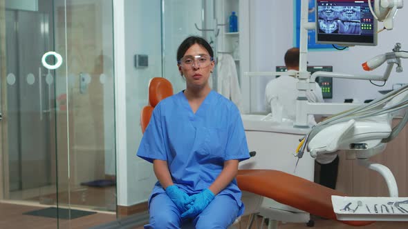 Dental Assistant Looking at Camera Speaking with Patients