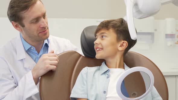 Mature Male Dentist Working with Charming Young Boy