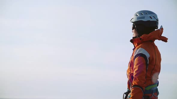 Woman Climber Dressed in Special Clothes, Standing on Top of the Mountain