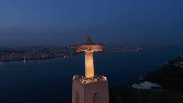 Night Drone Flying Toward Big Illuminated Statue of Jesus with Outstretched Hands