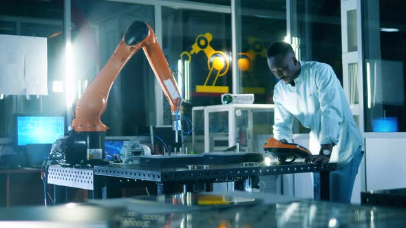 African Ethnicity Researcher Is Studying a Robot in a Science Laboratory