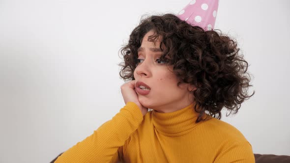 Upset Woman in Party Hat Looking Away Celebration Holiday Birthday Alone at Home