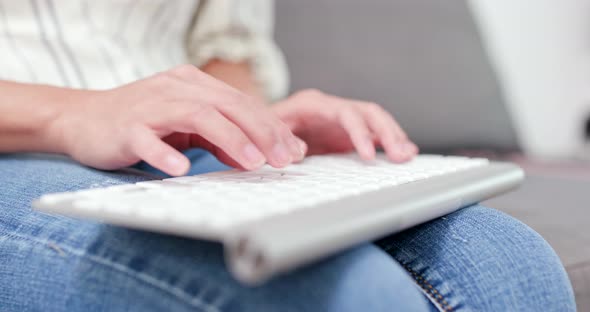 Woman typing on keyboard at home