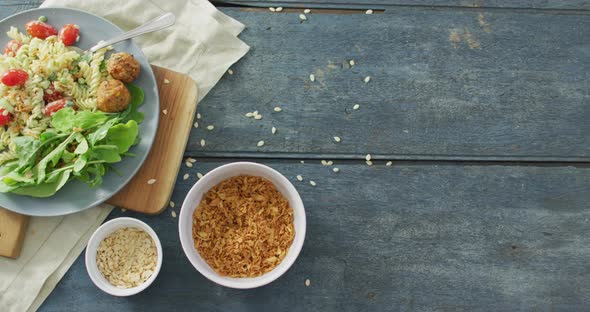 Video of fresh salad with green leaves and bowls with seeds on wooden background