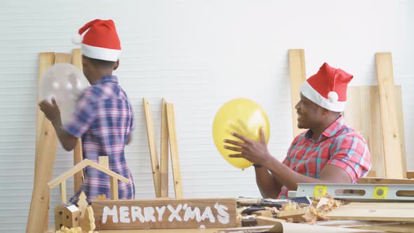 Christmas happy. Cheerful son carpenter dancing moves with balloon to happy with father 