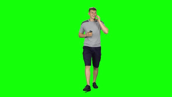Young Man Walking Talking on the Phone and Drinking Coffee. Chroma Key