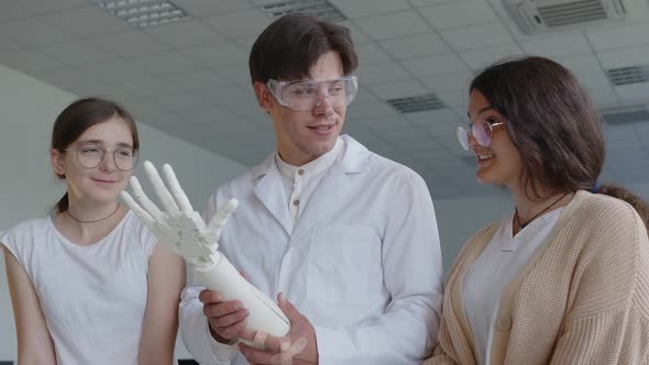 Close Up View of Pupils and Teacher with 3D Printed Hand