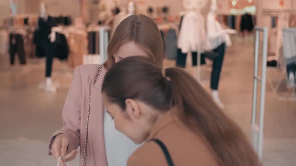 Cheerful Female Friends Chatting before Clothes Shop