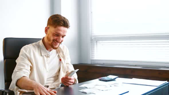 Satisfied successful businessman with beard gathers money banknotes