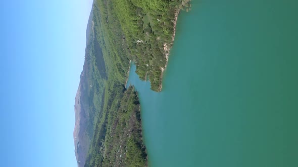 Aerial parallax above lake formed by Maneciu Dam, Romania. Vertical video