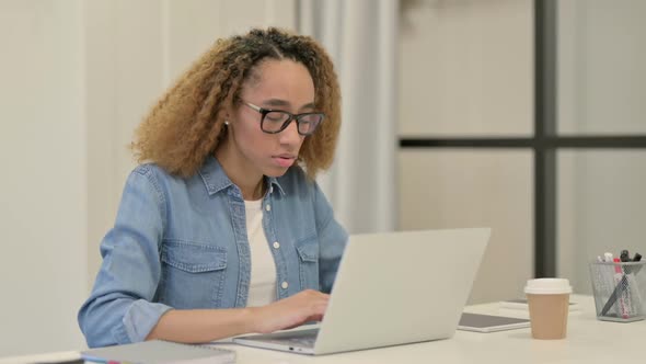 African Woman Showing Thumbs Up Sign While Using Laptop in Office