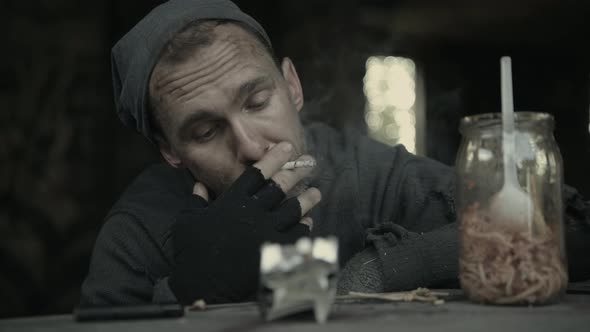 Homeless Men in His 40s Drinking Alcohol and Smoking Cigarette