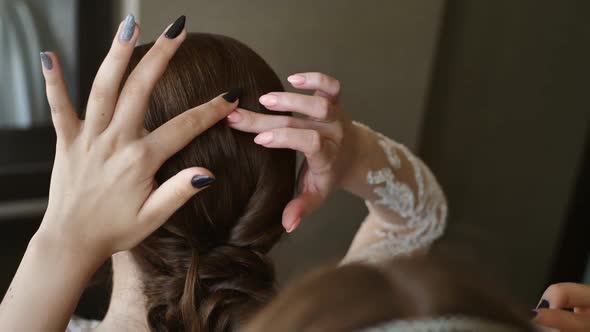 Bridesmaid Inserts a Veil Into the Bride's Hair Before the Wedding