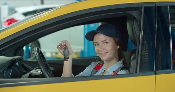 Portrait of Car Female Mechanic in a Car, with Keys in Her Hands. Concept: Repair of Machines, Fault