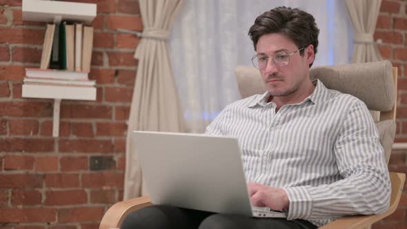 Middle Aged Man Working on Laptop on Sofa