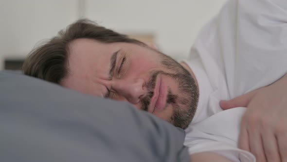 Portrait of Young Man Coughing While Sleeping in Bed