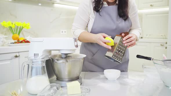 a Woman Cook Makes Lemon Zest on a Grater to Make Pastries or Cream