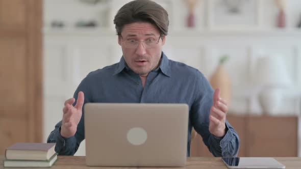 Young Man Reacting to Loss While using Laptop