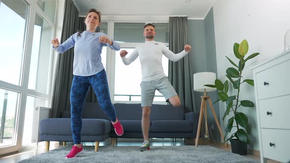 Caucasian Couple is Doing Cardio Exercise at Home in Cozy Bright Room Slow Motion