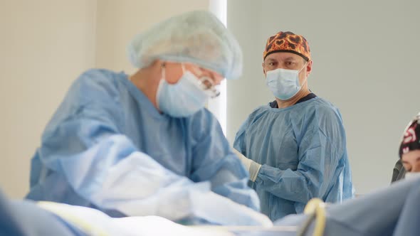 Surgeons Team Preforming Operation in Hospital Operating Theater Male Surgeon