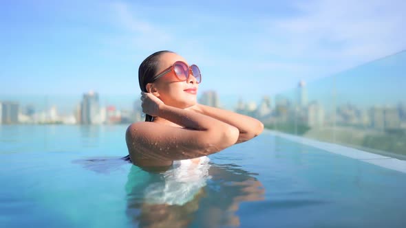 Young asian woman enjoy around outdoor swimming pool for leisure