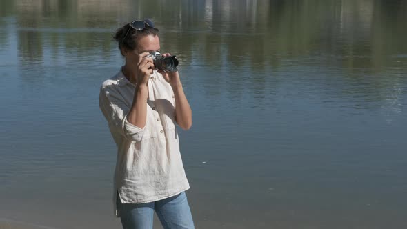 Female tourist with a camera on nature.