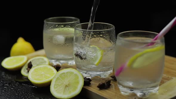 Pour Lemon Juice Into Glass with Ice and Lemon Slices. Lemon Alcoholic Cocktail