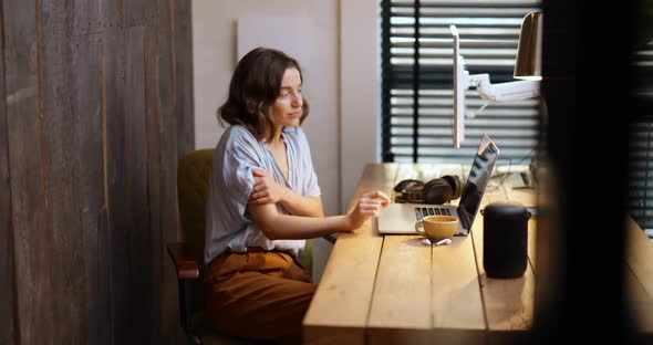 Woman Controlling Temperature with a Thermostat at Home Office