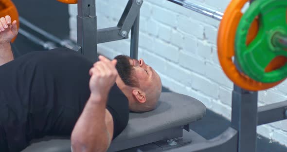 Brutal Athlete Lays on a Sports Bench Prepares to Do a Bench Press