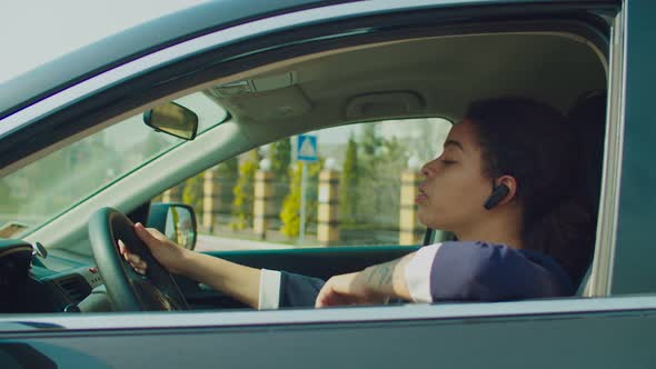 Female Driver Using Wireless Phone Headset in Car
