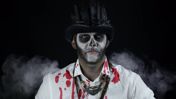 Sinister Man with Halloween Skeleton Makeup in Shirt with Blood Looking at Camera, Trying To Scare