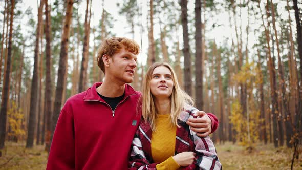 Young Man Hugging Girlfriend in Checkered Plaid