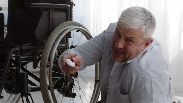 Disabled Senior Man Lying On Floor Pushing Emergency Button Indoor