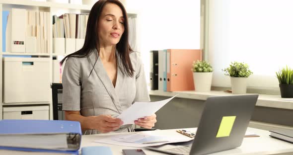 Businesswoman Works with Documents in Office and Sneezes