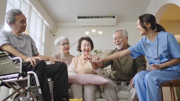 Group of Asian senior people in nursing home forming hands stack to build morale for yourself