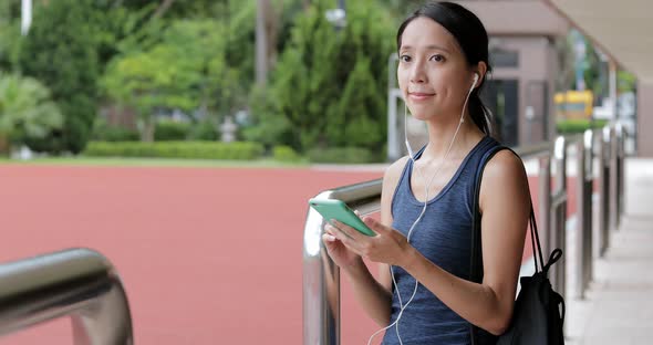 Sport woman using earphone in sport arena 