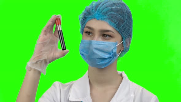 Portrait of Young Female Doctor with Blood Test Capsule