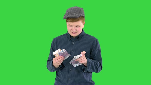 Rich Teenager in a Cap Counting Euros on a Green Screen Chroma Key
