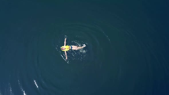 Little boy swimming in crystal clear water. Happy children on summer vacation. Aerial view.