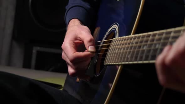 Man Plays a Pick on a Modern Guitar in the Dark Slow Mo