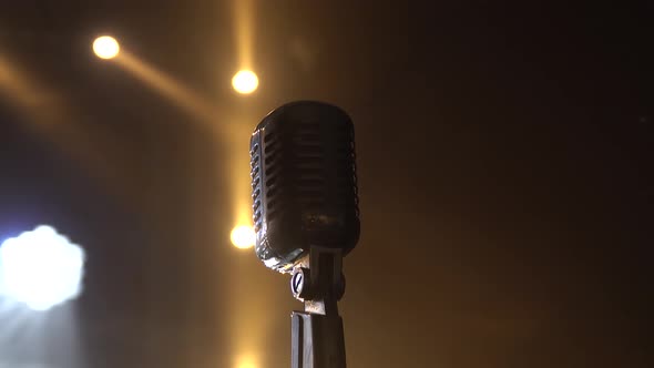 Classic Retro Chrome Microphone in Dark Studio with Smoke and Neon Lighting. Dynamic Neon Lighting