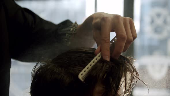 Close Up Shot of Barber Moisturizes Hair with Water