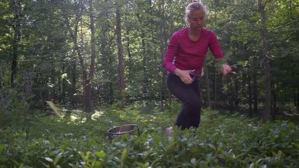 Mature, beautiful woman picking fresh, home grown arugula in a garden. The ultimate farm to table. S