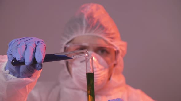 Protected Scientist Pouring Liquid in a Laboratory. Research and Science Concept