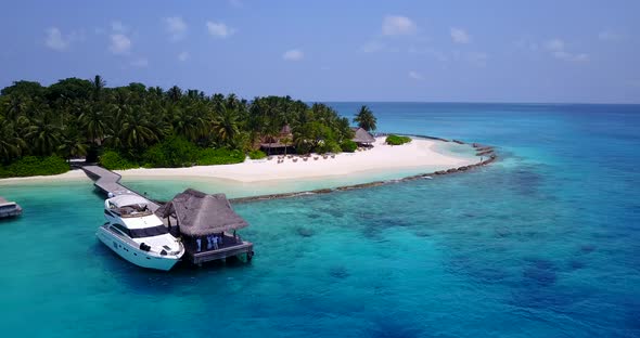 Wide drone travel shot of a sandy white paradise beach and aqua blue water background in hi res 4K