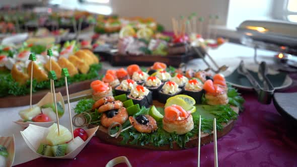 A set of seafood rolls with fish, caviar, shrimps and cream cheese on a buffet table
