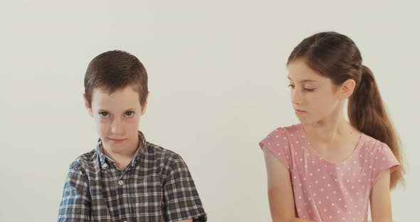 Brother and sister arguing and fighting on a white studio background