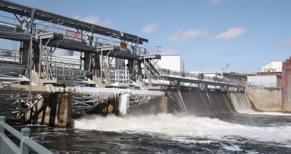 River flowing through dam with some ice on dam.