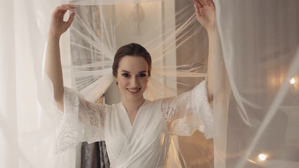 Bride in Boudoir Dress Under Veil and in a Silk Robe Wedding Morning Preparations Before Ceremony